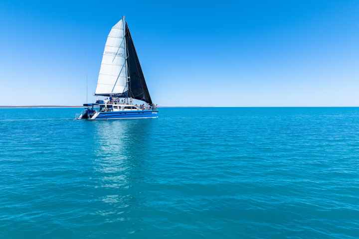 Sailboat on calm blue sea under clear sky